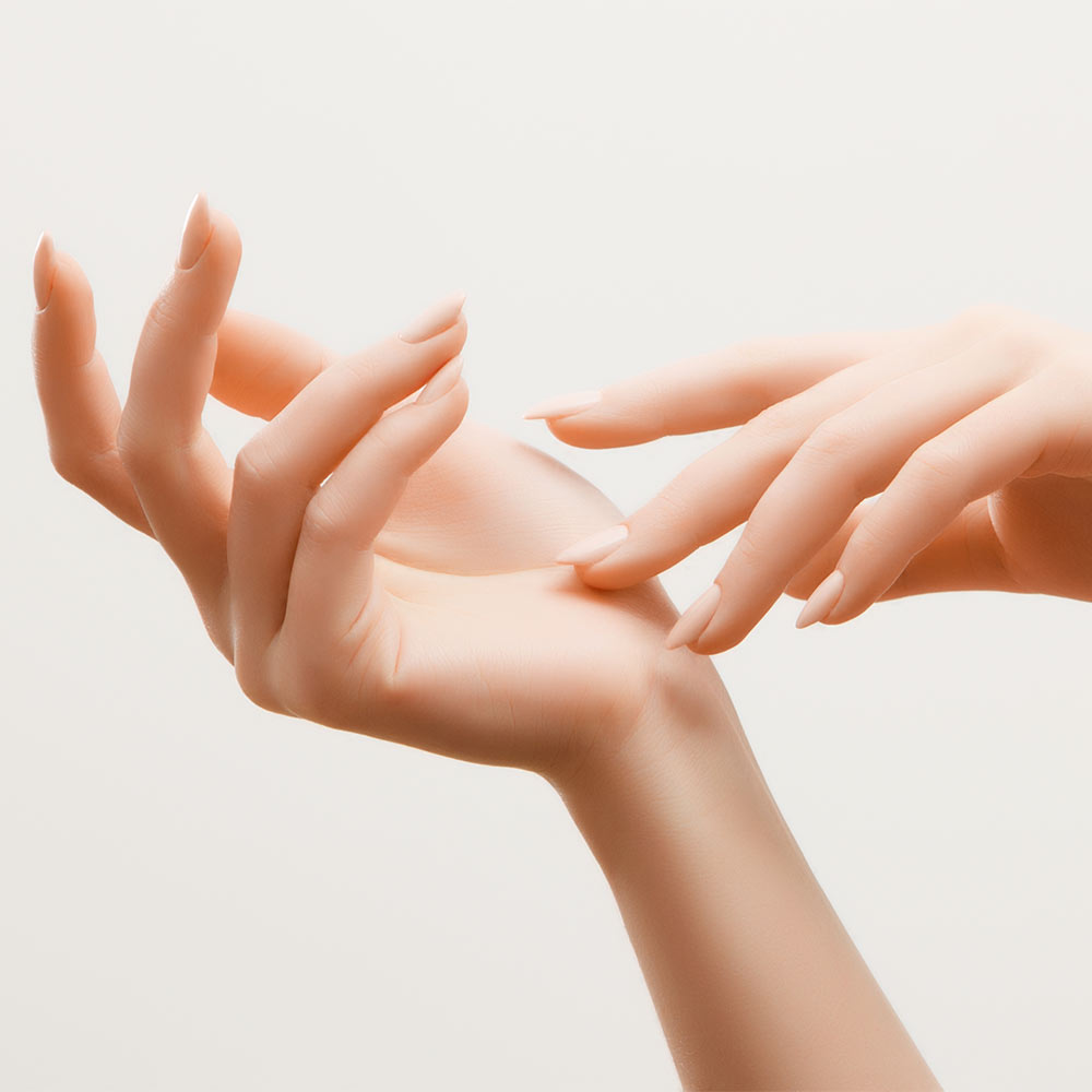 Closeup image of beautiful woman's hands with light pink manicure on the nails. Skin care for hands, manicure and beauty treatment. Elegant and graceful hands with slender graceful fingers